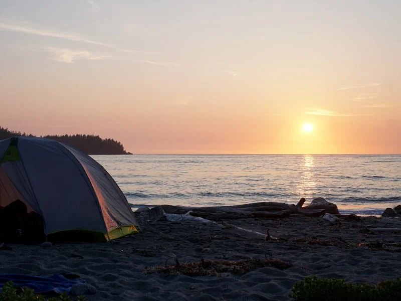 Small tent on Vancouver Island beach during sunset