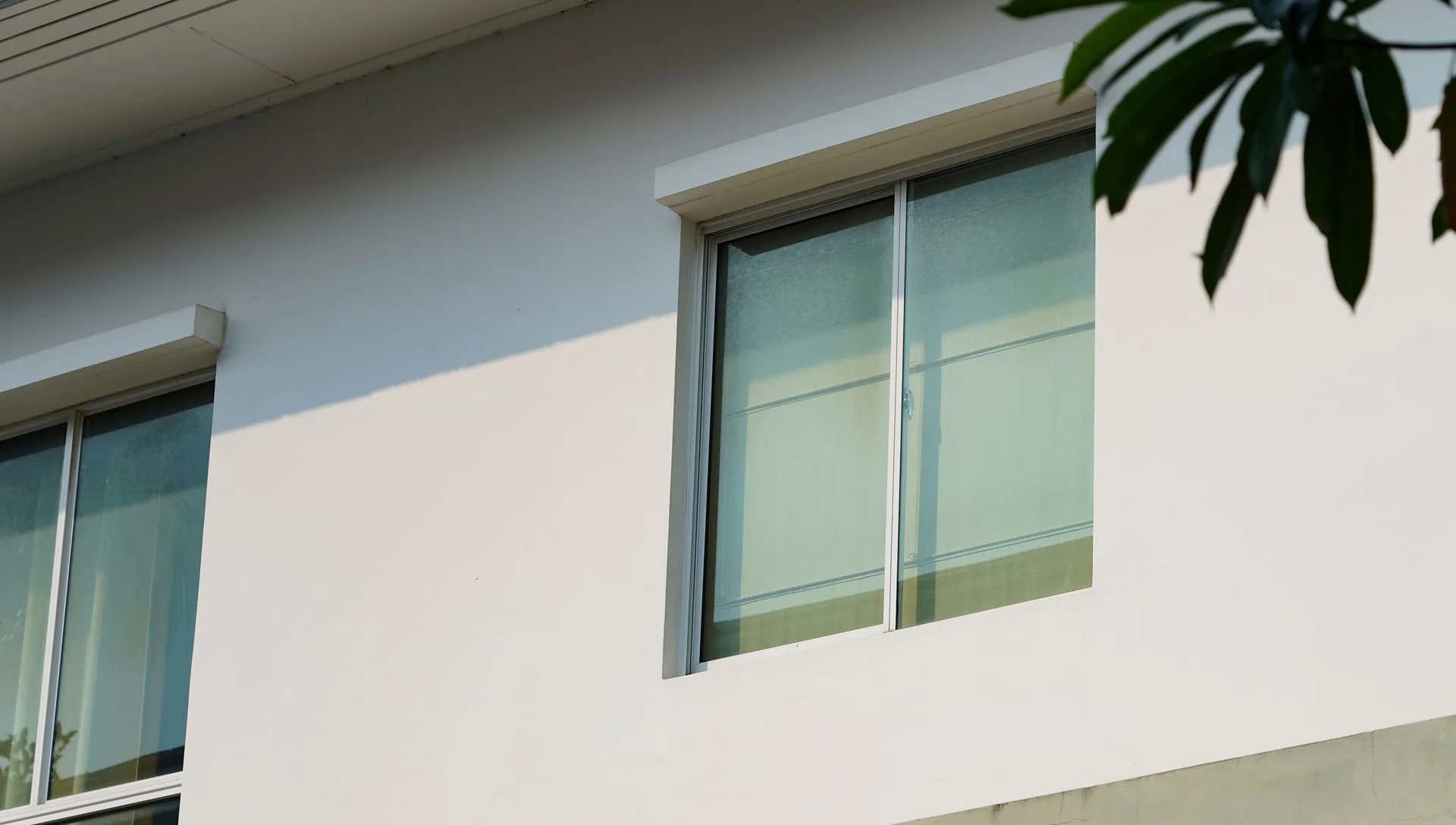 Exterior of all stucco condo complex with two windows