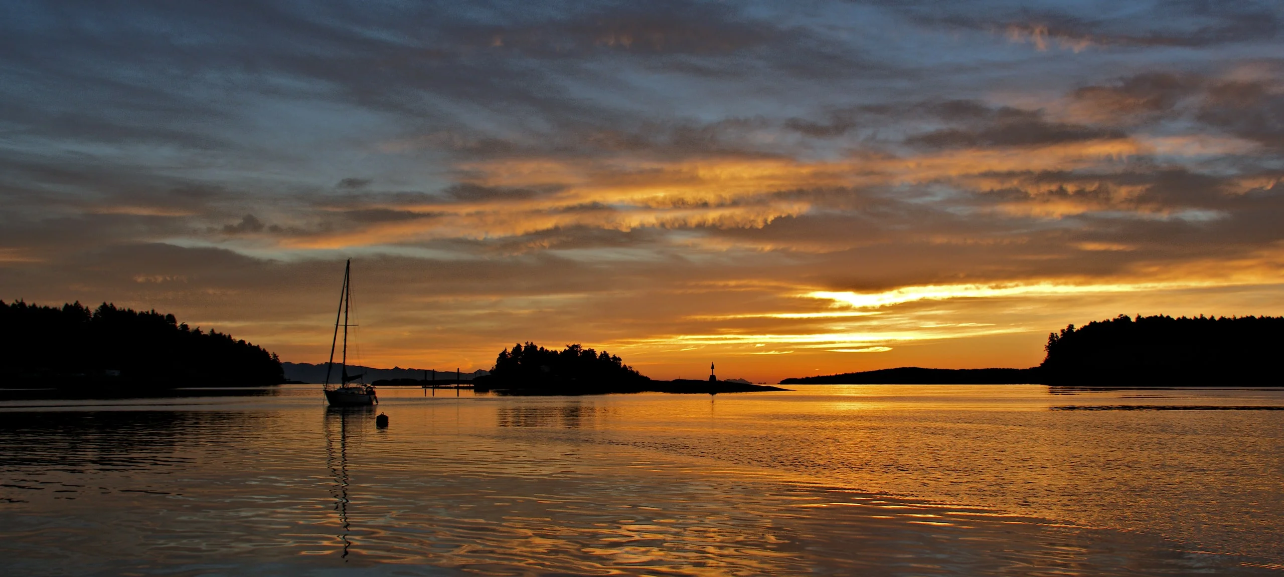 Sunrise over the Strait of Georgia and Gulf Islands, with one sailboat on the water