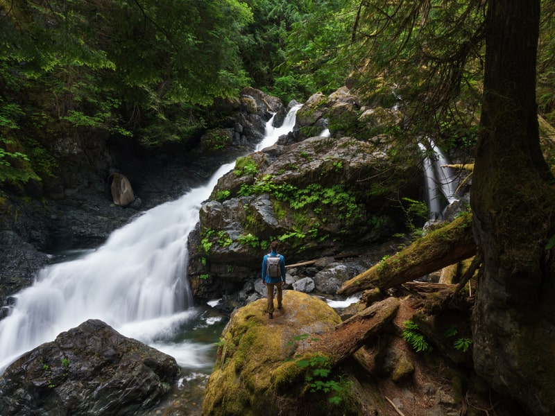 Person standing on rock looking at Therriault Falls