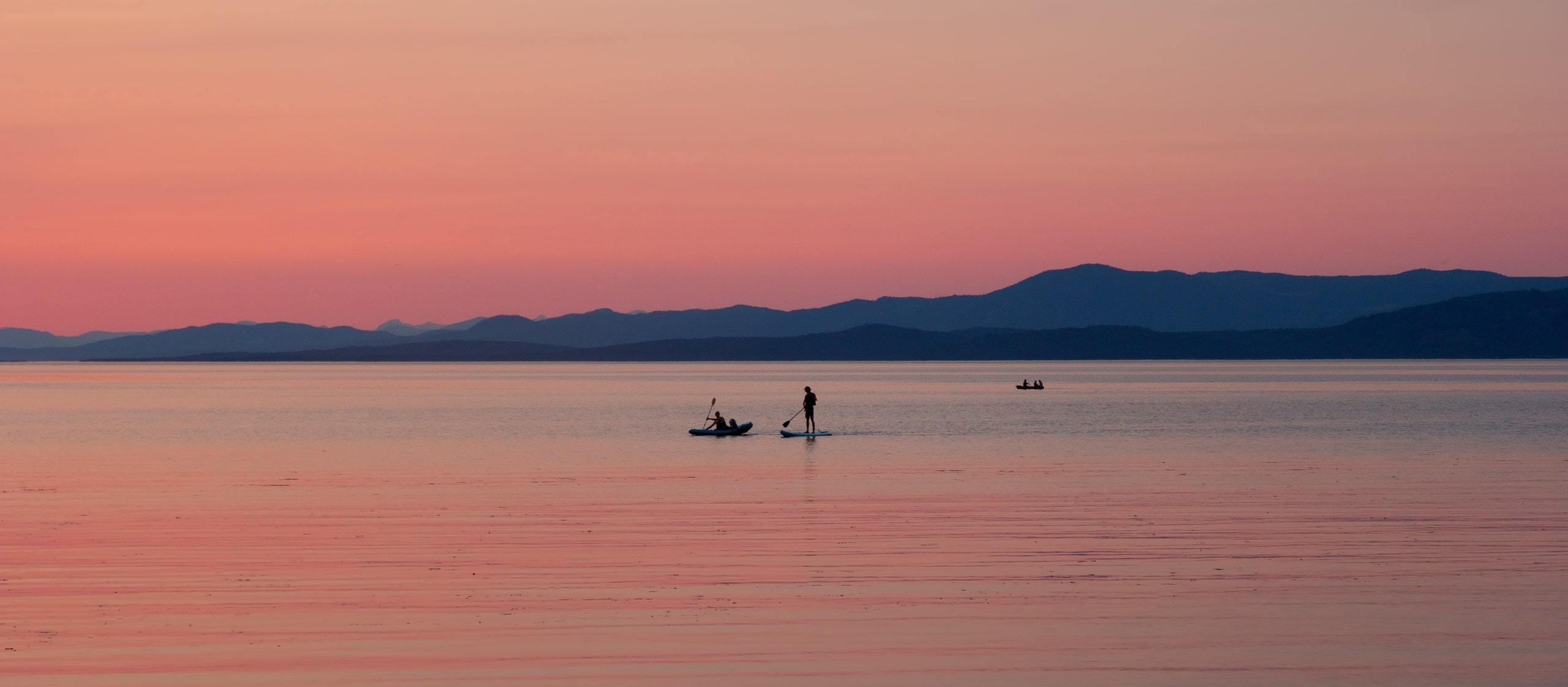 Paddleboarders on Parksville water during sunset