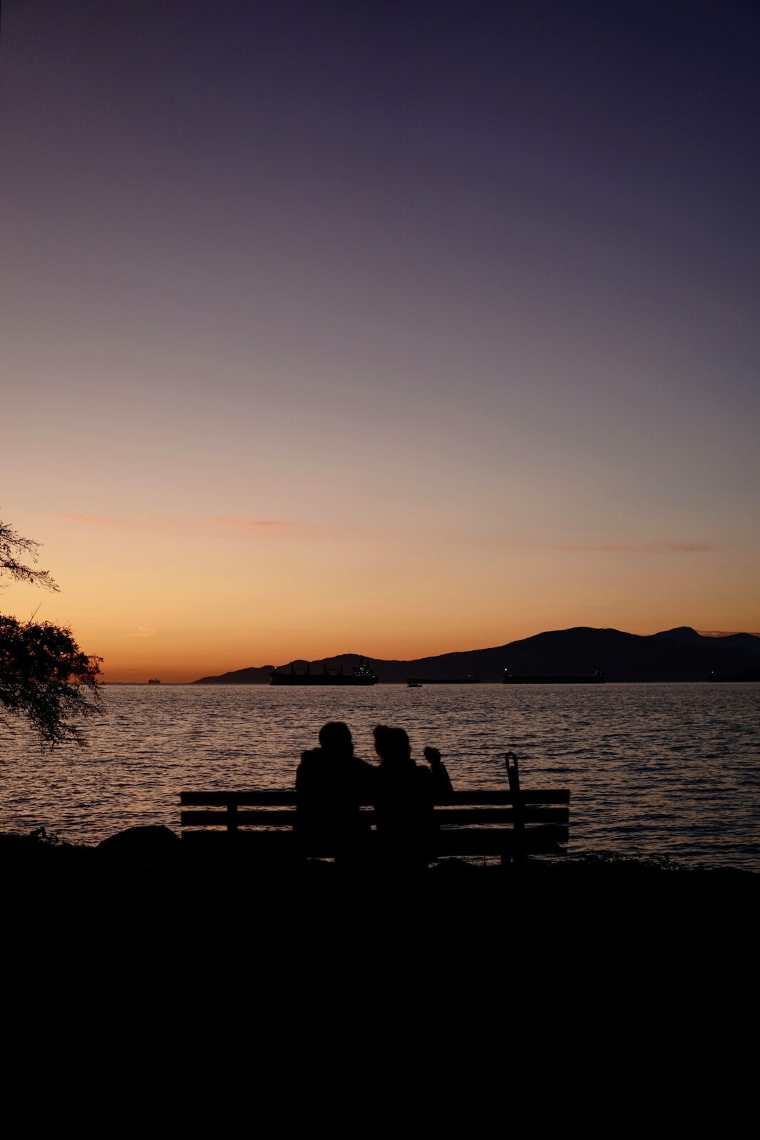Silhouette of couple on bench watching sunset. Photo by Dmitry Spravko on Unsplash.