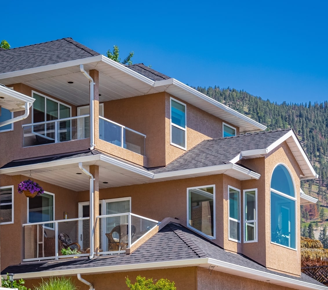 Large stucco condo complex with trees in background