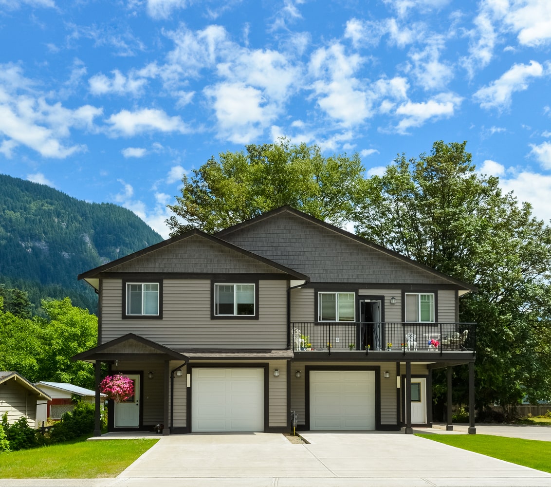 Rustic, cabin-style duplex with mountains in background