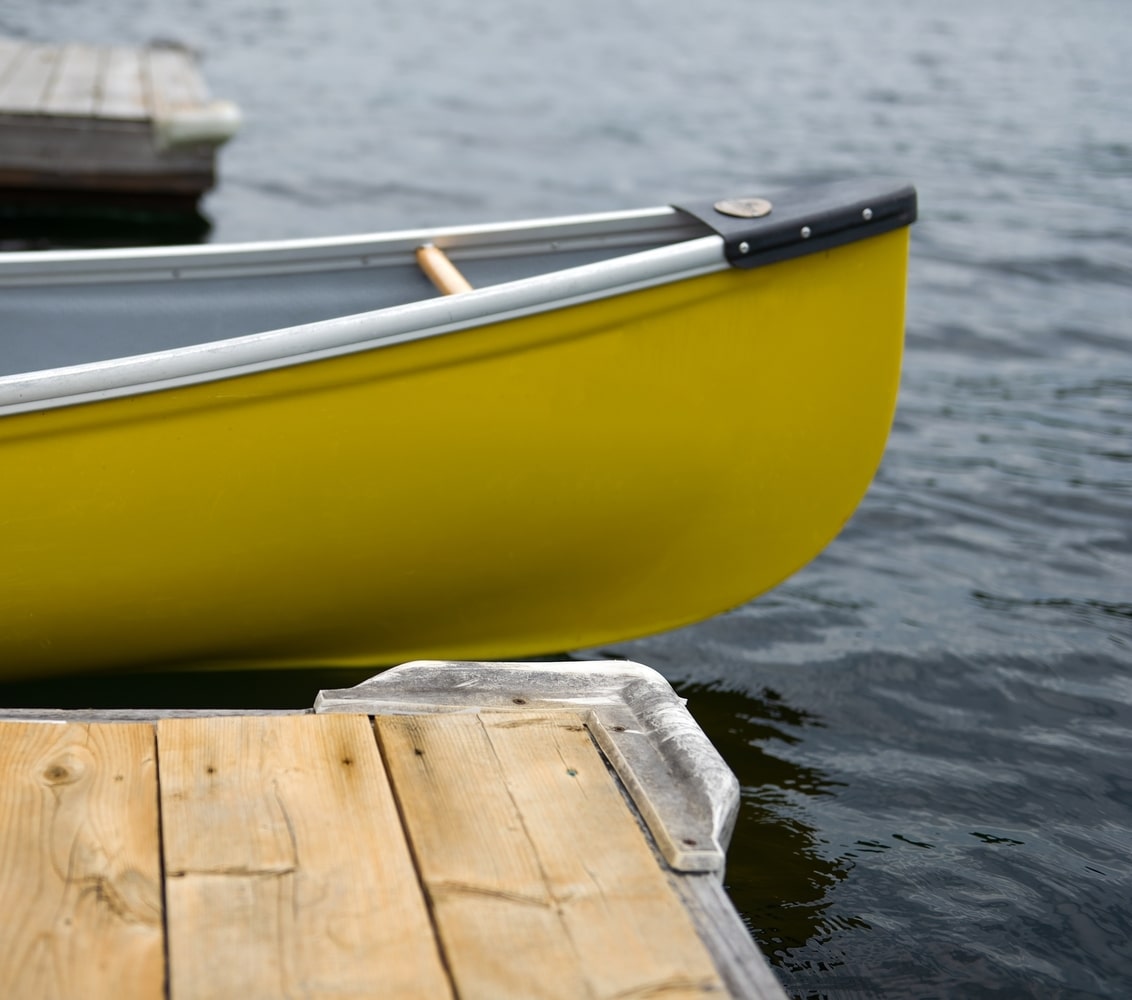 Yellow canoe hooked up to private dock on lake